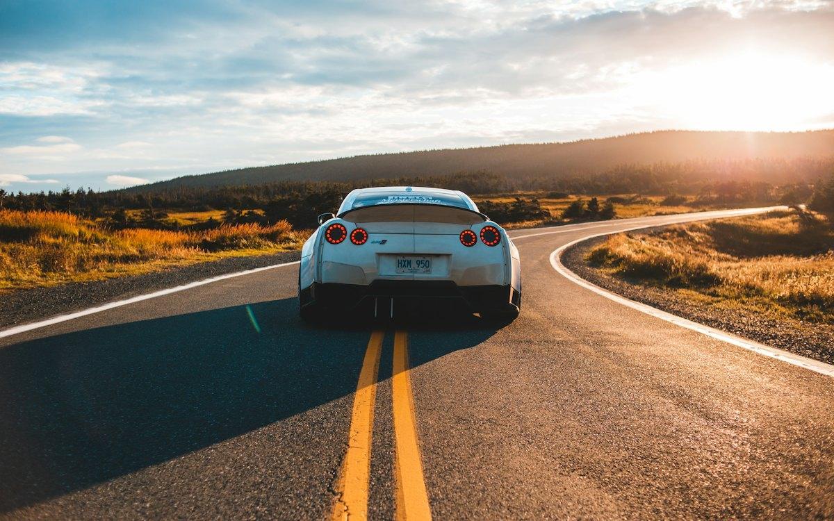 Carro em uma estrada ao pôr do sol