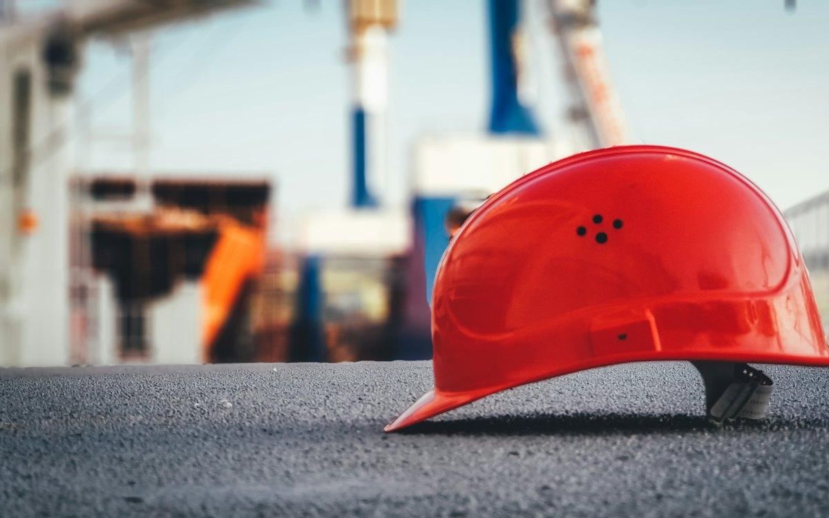 Capacete de segurança sobre o asfalto de uma obra
